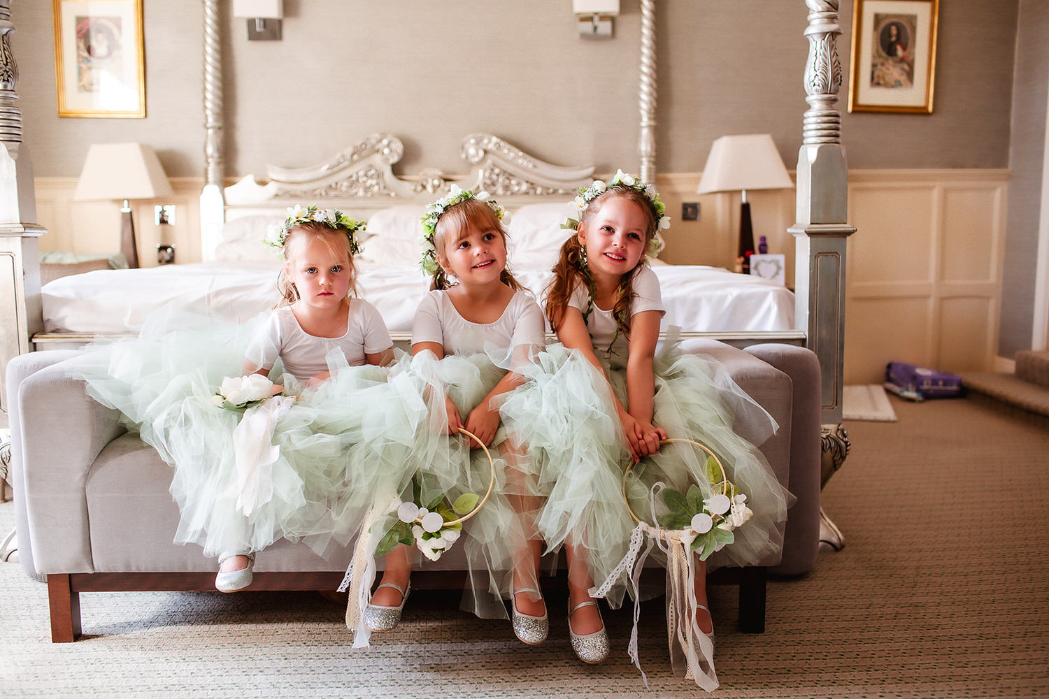 flower girls in green fairy skirt and white tops with the flowers on their heads.