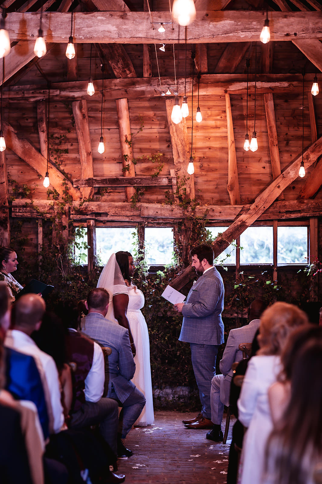 rusting and dark indoor wedding ceremony atHigh Billinghurst Farm, Godalming wedding photographer