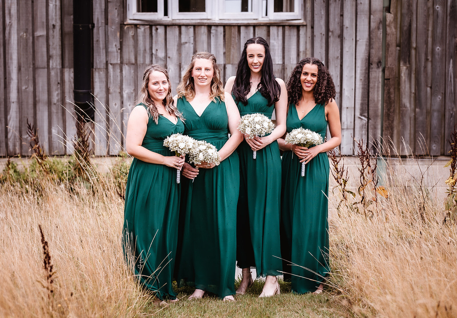 bridesmaids in green long summer dresses holiding their flowers at High Billinghurst Farm, Surrey wedding venue