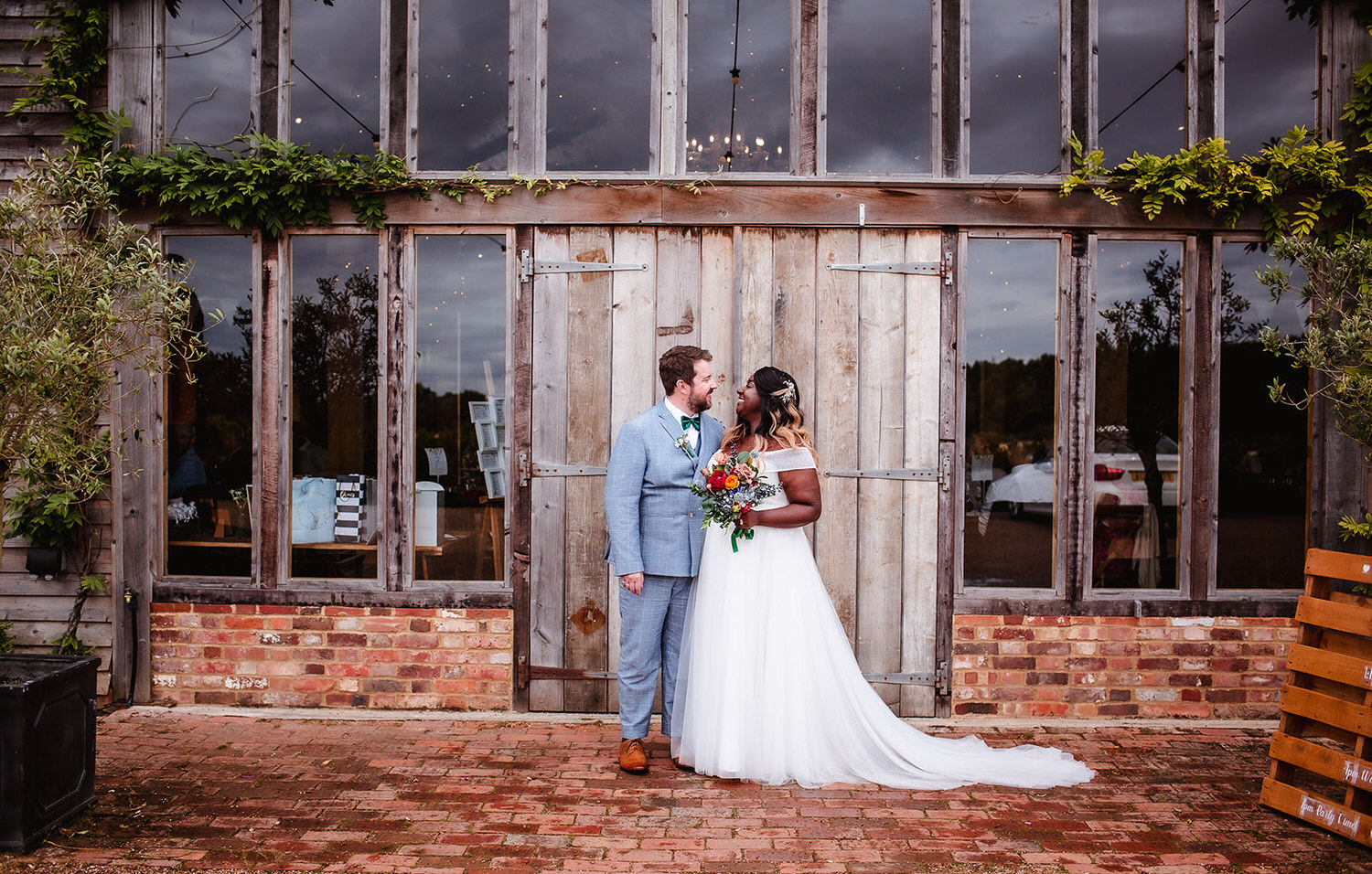 wedding photo of bride and groom at the rustic wooden gate High Billinghurst Farm