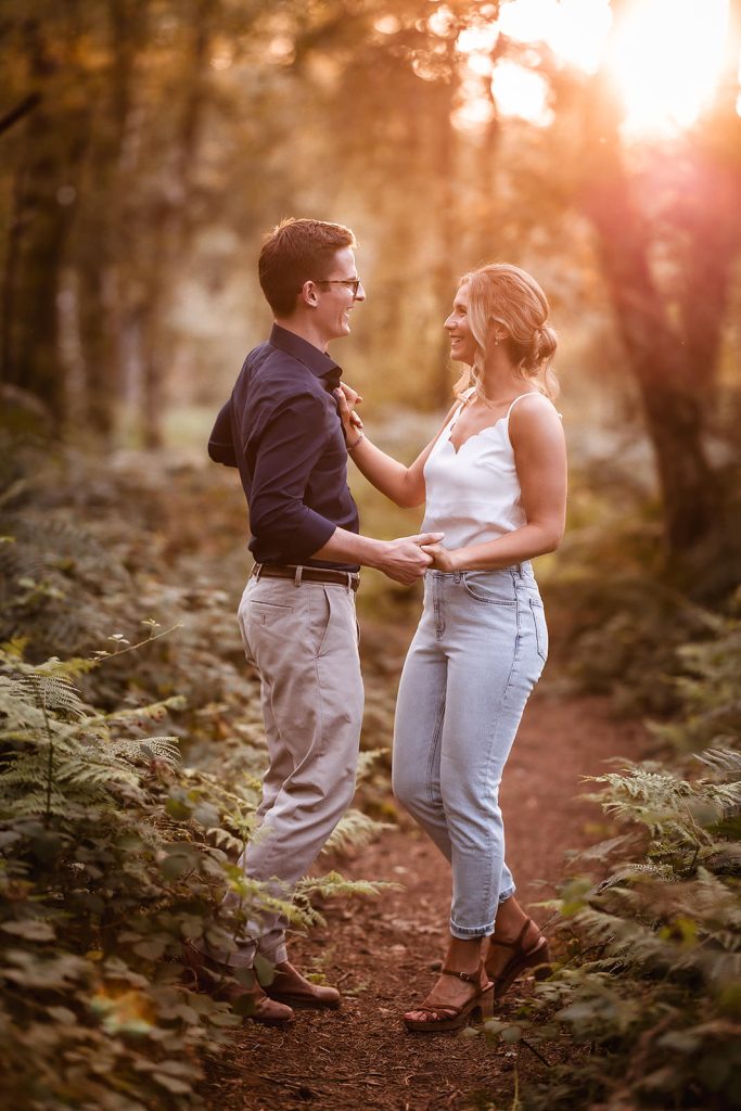 couple dancing in the forest during the sunset in Hampshire. 