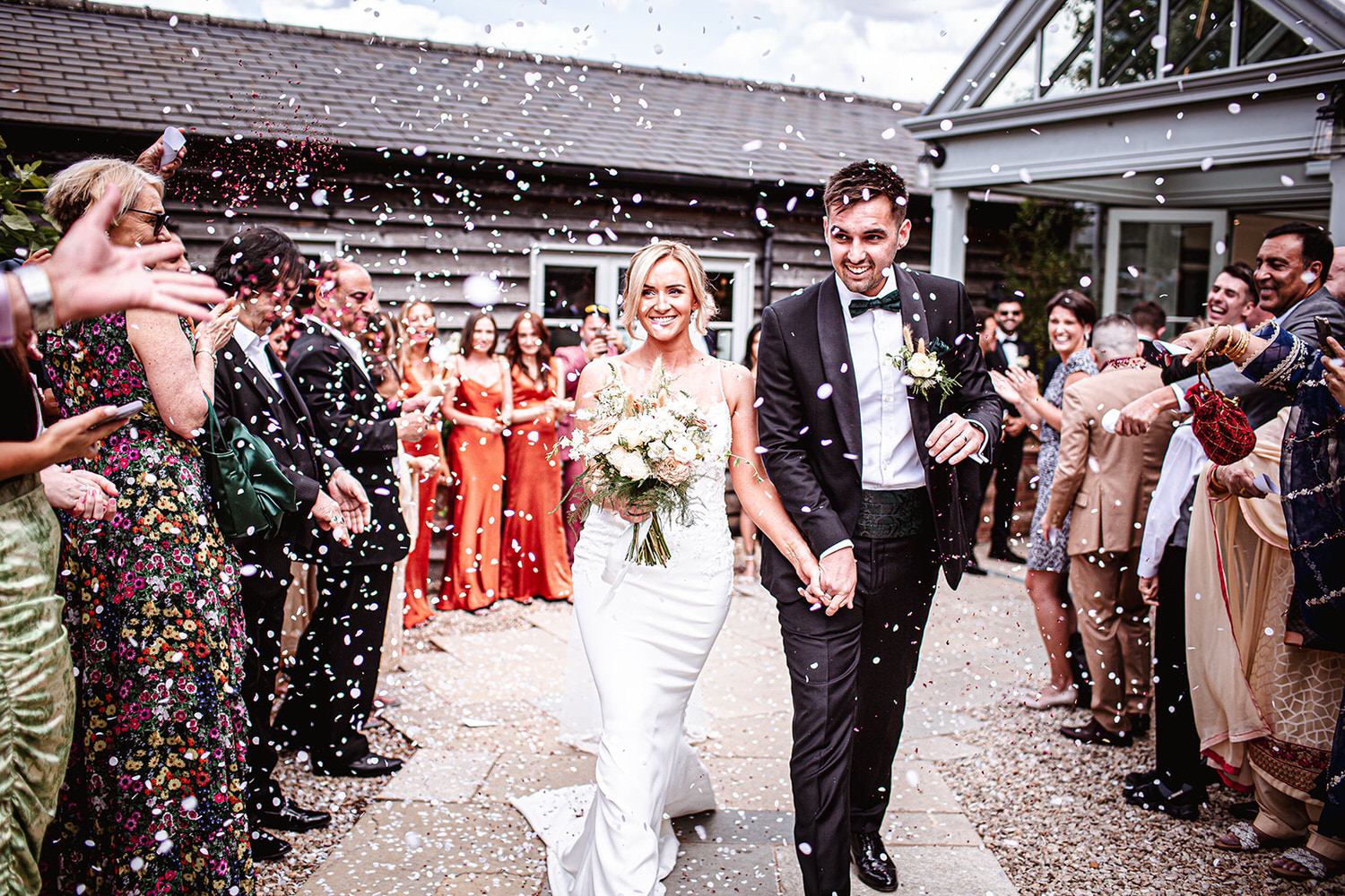 Confetti photo of bride and groom outside Gate Street Barn