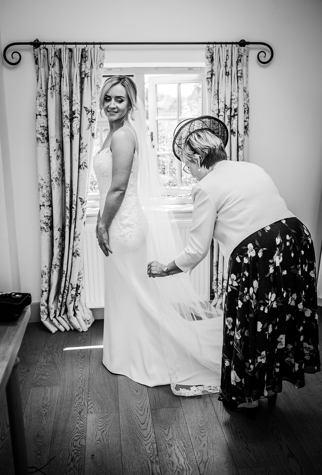 bride is putting her dress on with assistance of her mum at Gate Street