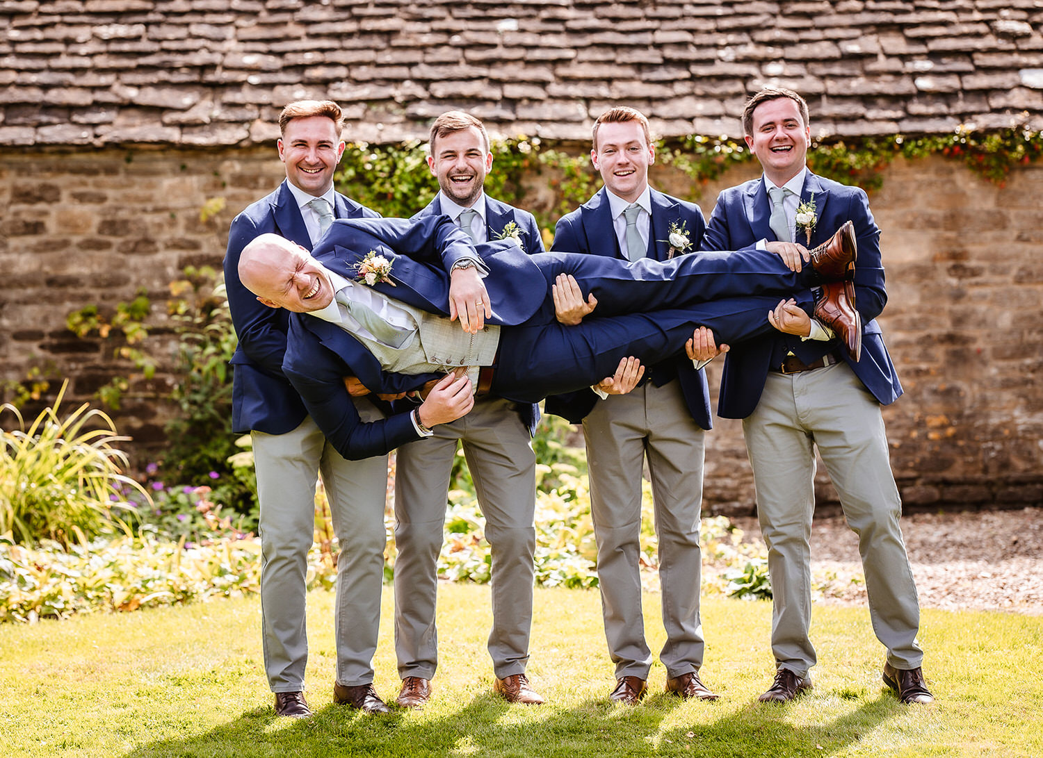 fun photo of groomsman holding a groom at Wiltshire wedding venue