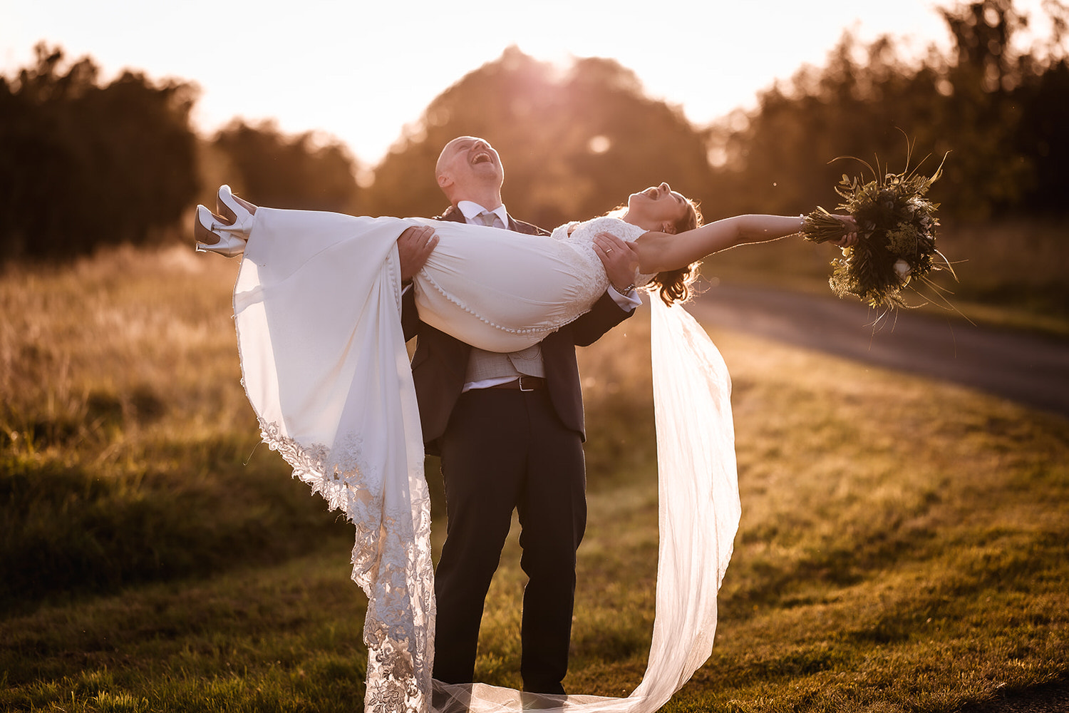 fun photo of bride and groom during the sunset