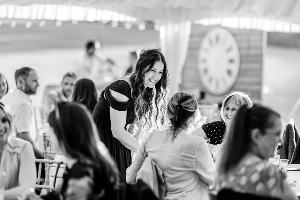 Natural and candid wedding photography. Wedding guests having a chat and fun