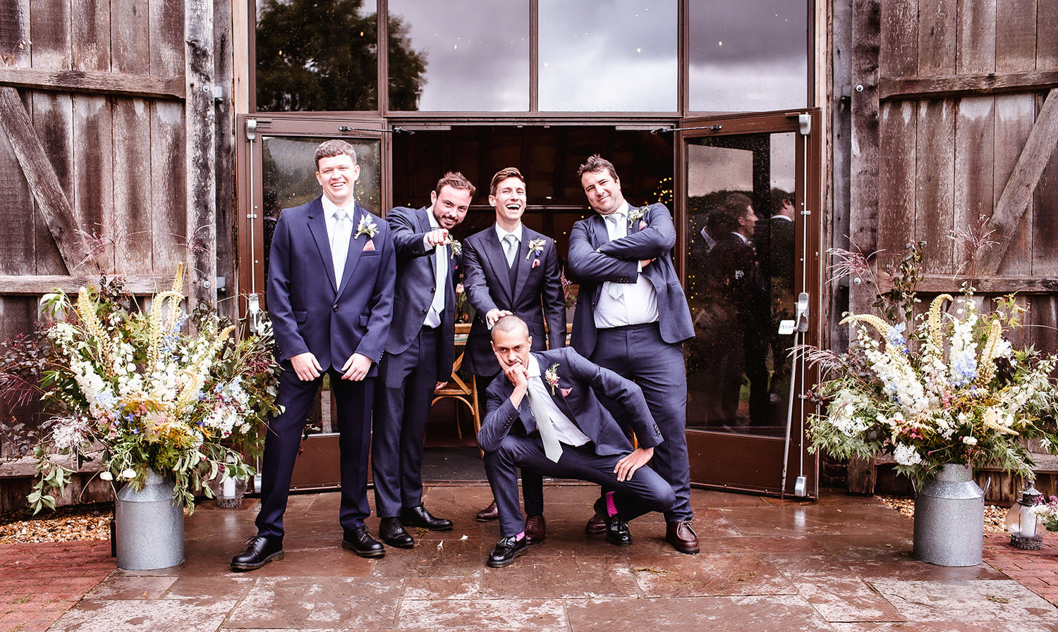 fun and relaxed photo of groom with groomsmen at the wooden barn