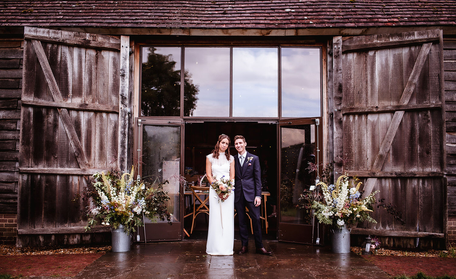 bride and groom photo outside the wooden barn with big glass door