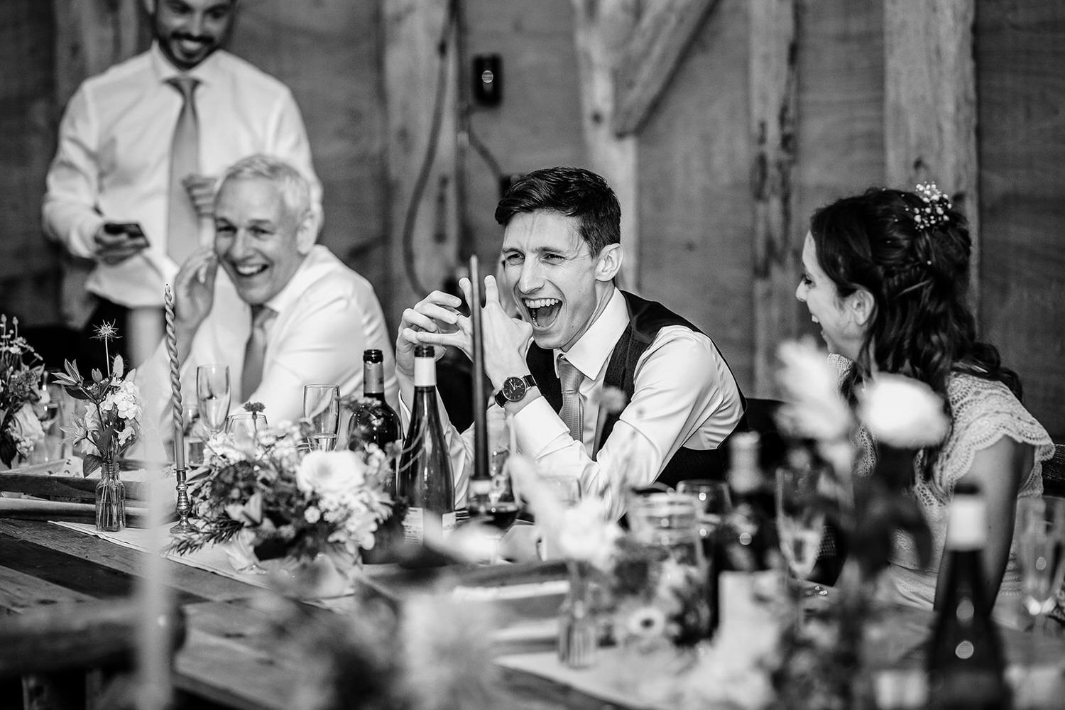 fun and candid wedding photo during the speech at rustic barn wedding venue in Hampshire