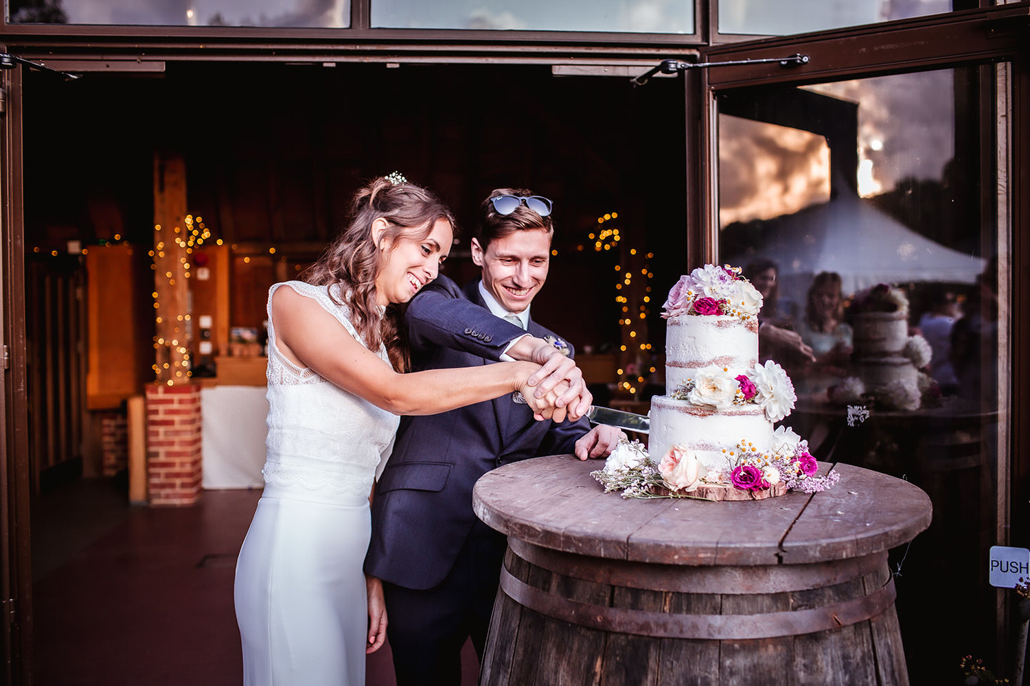 bride and groom cutting a wedding cake at Barn