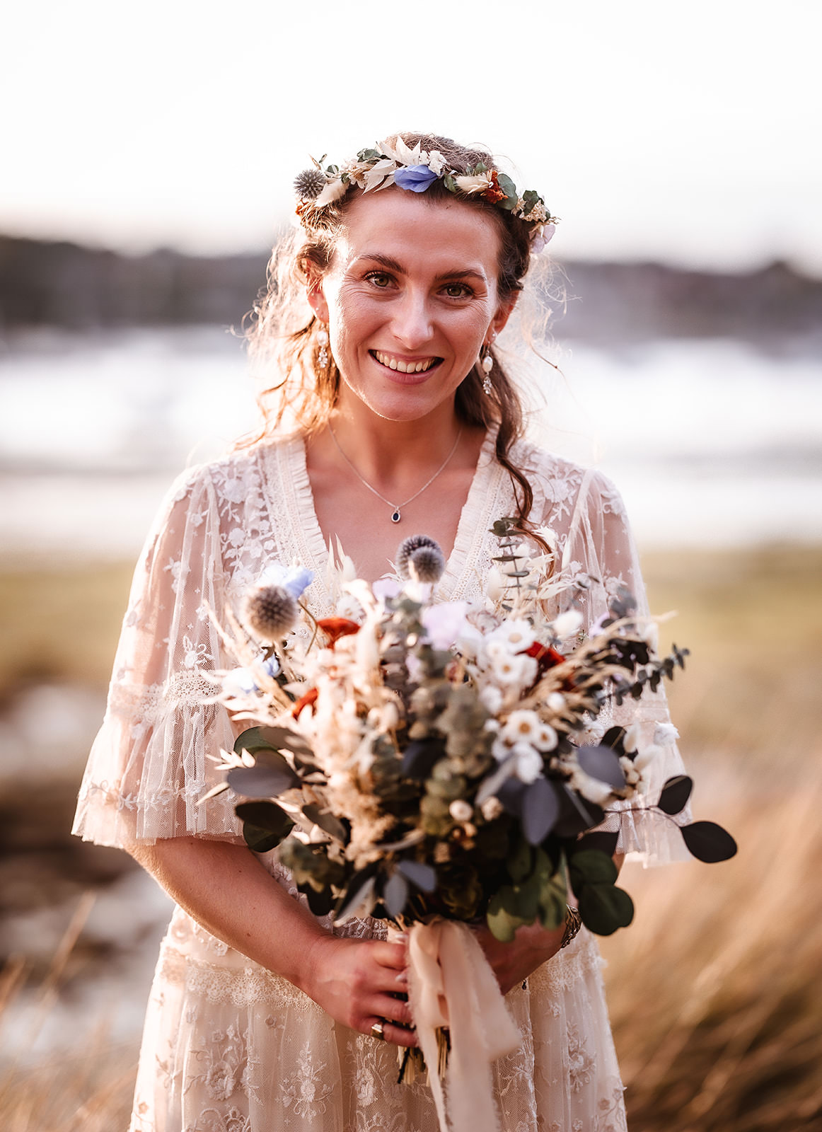 Boho portrait photo of bride holding her dry flowers.