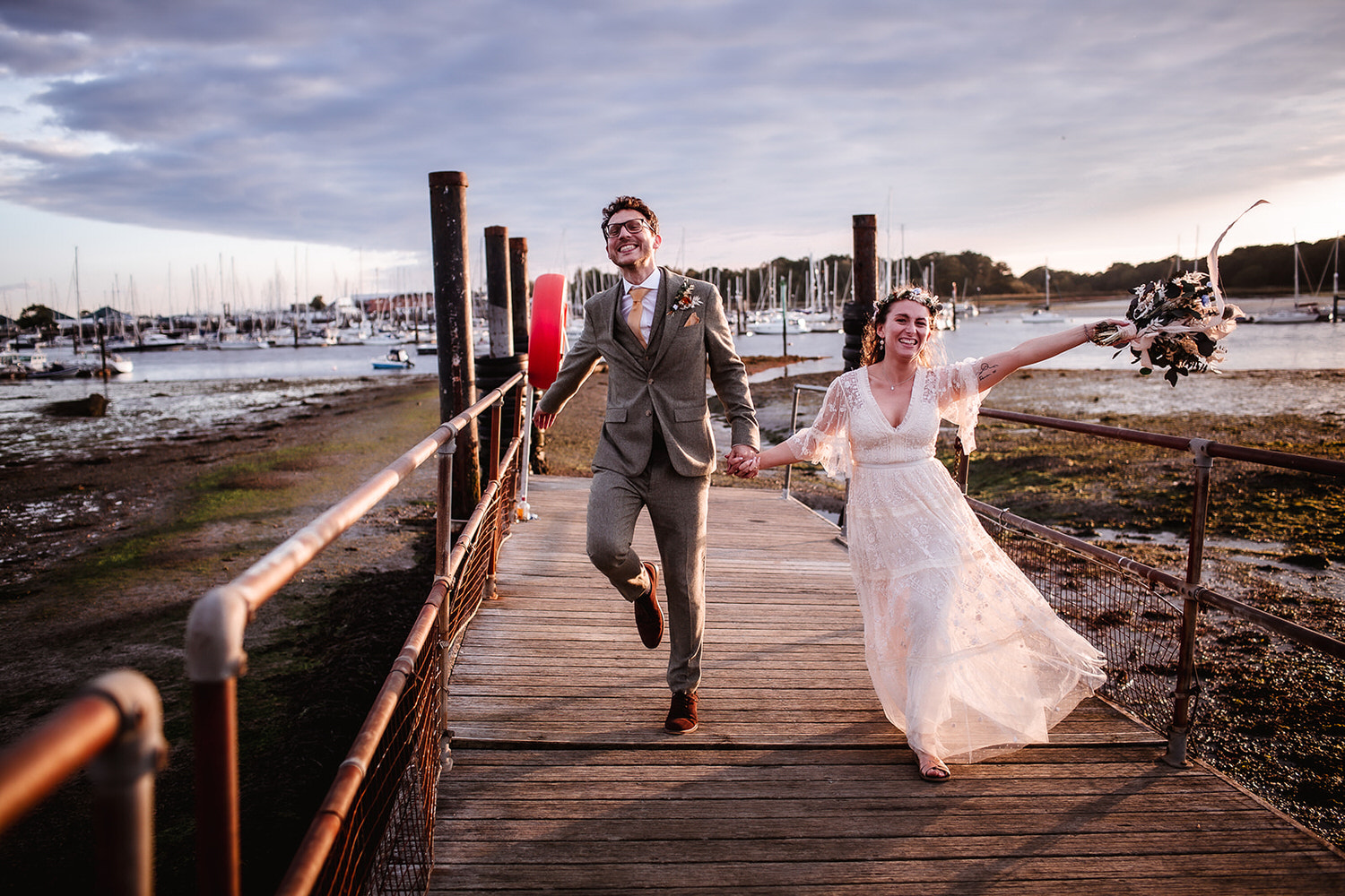 happy wedding couple jumping and running at the Harbour. Southampton wedding photography