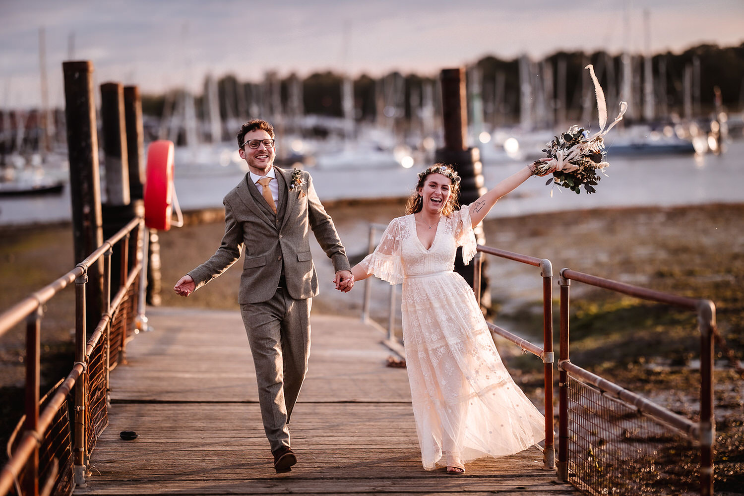 happy bride and groom running at the Harbour