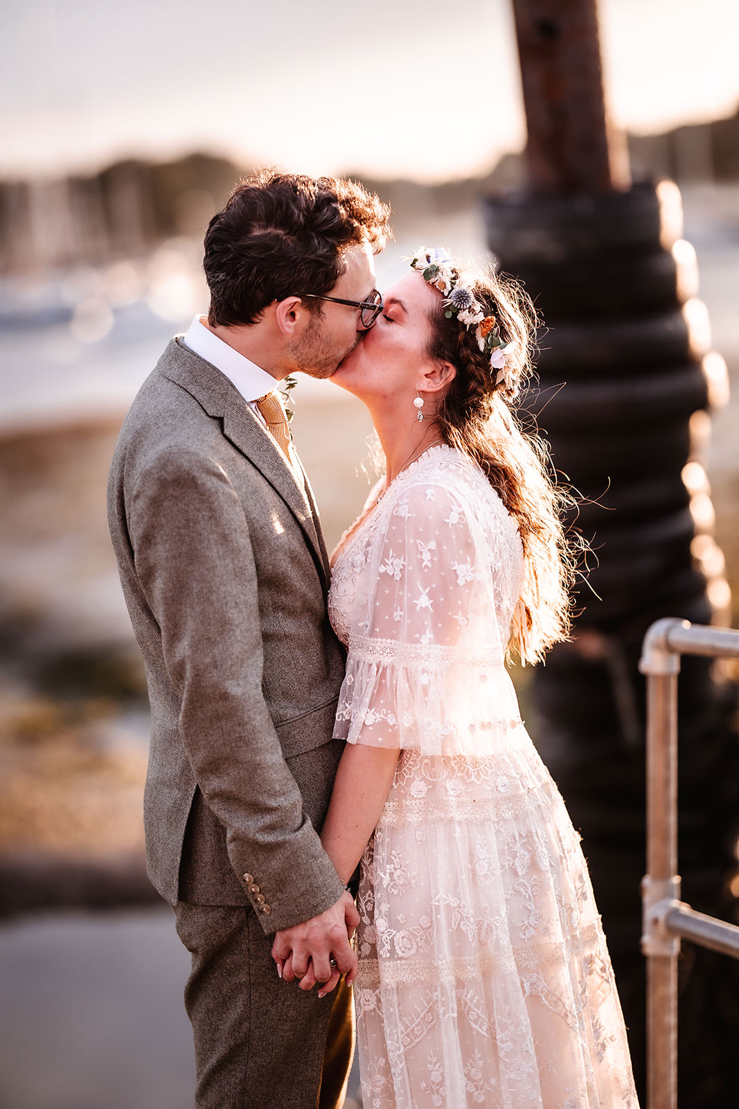 sunset photo of bride and groom kissing at the harbour