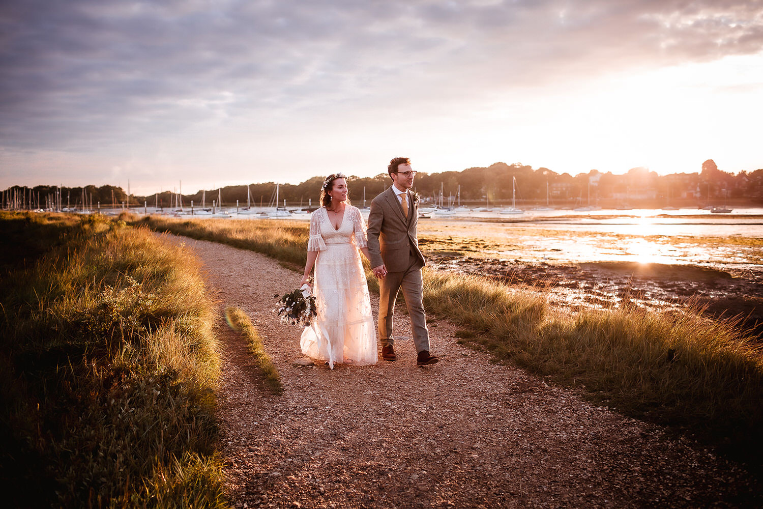 natural sunset photo of bride and groom walking hand in hand at the harbour in Southampton