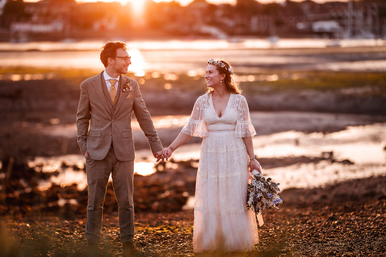 sunset photo of bride and groom holding hands and looking at each other at Warsash Harbour