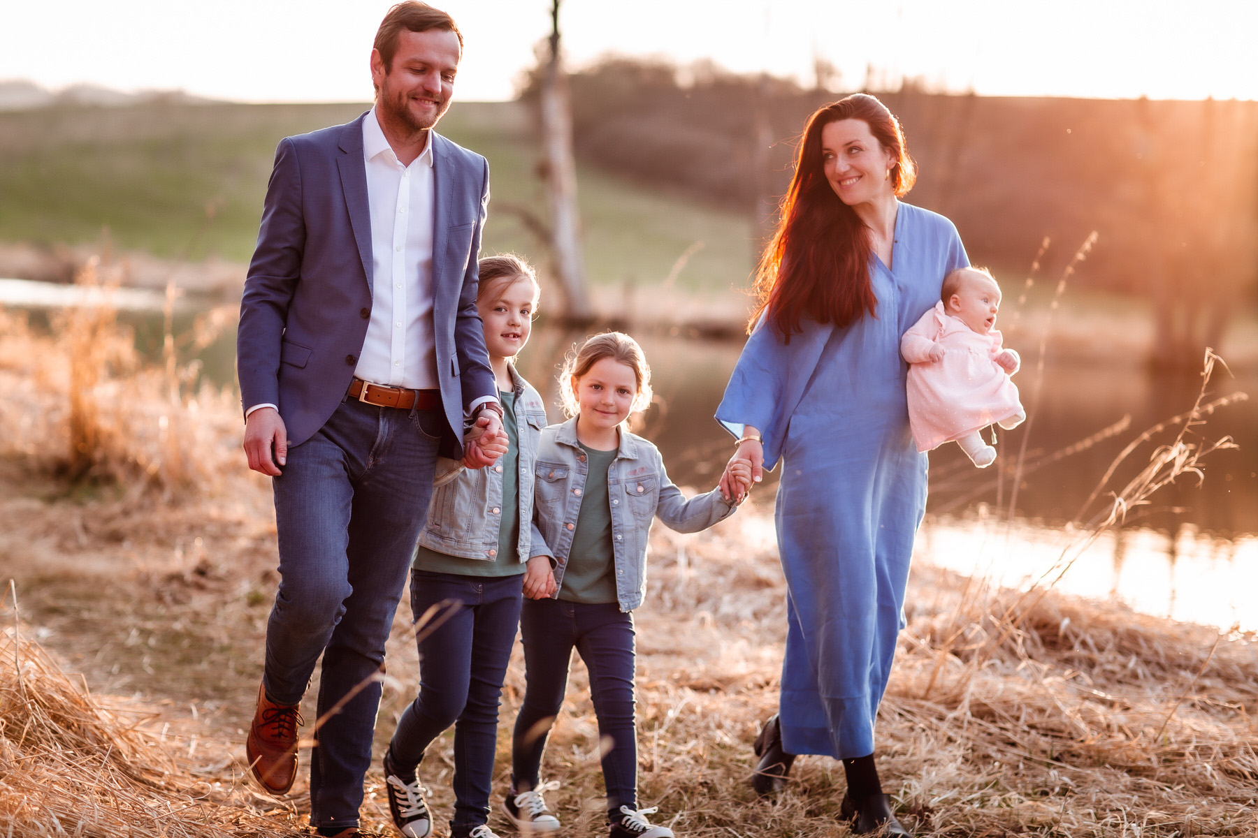 sunset family newborn photos. family waking in the field