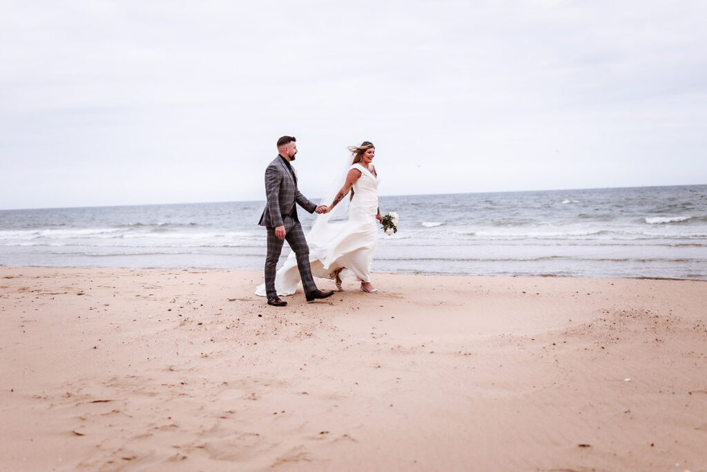 beach wedding photos. bride and groom walking on the beach