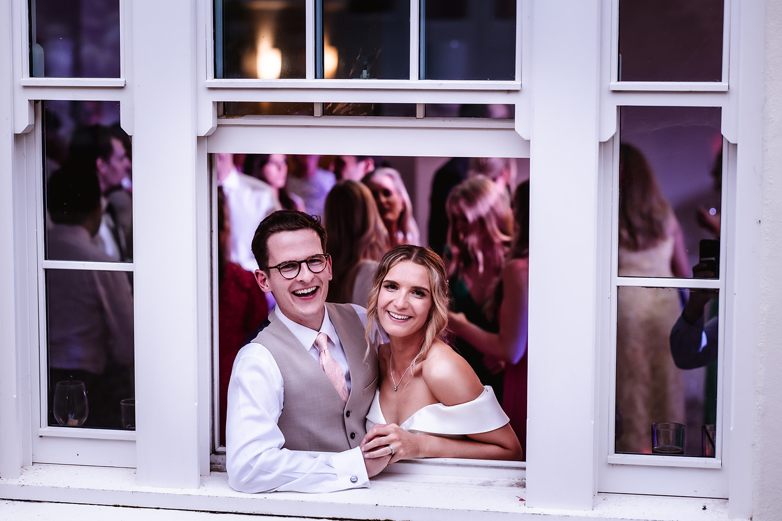 bride and groom looking out of the window during the dance at the wedding