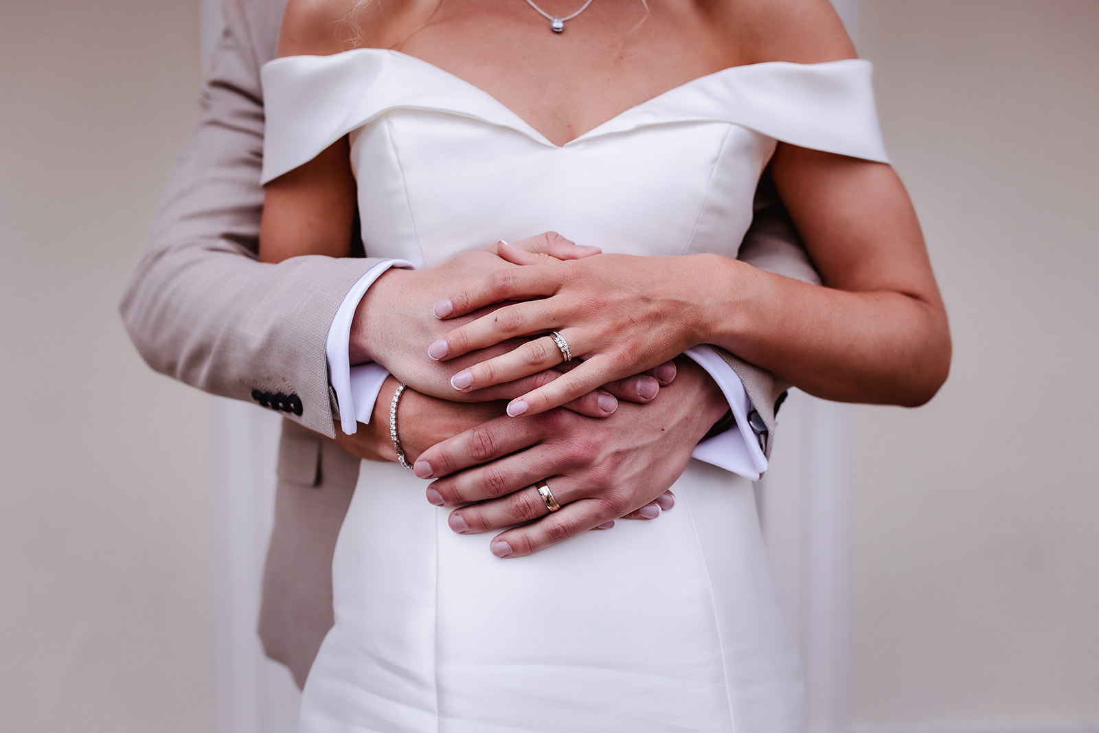 bride and groom holding hands with their wedding rings