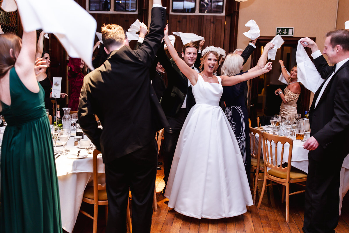 wedding reception entrance of bride and groom with everyone waving their napkins