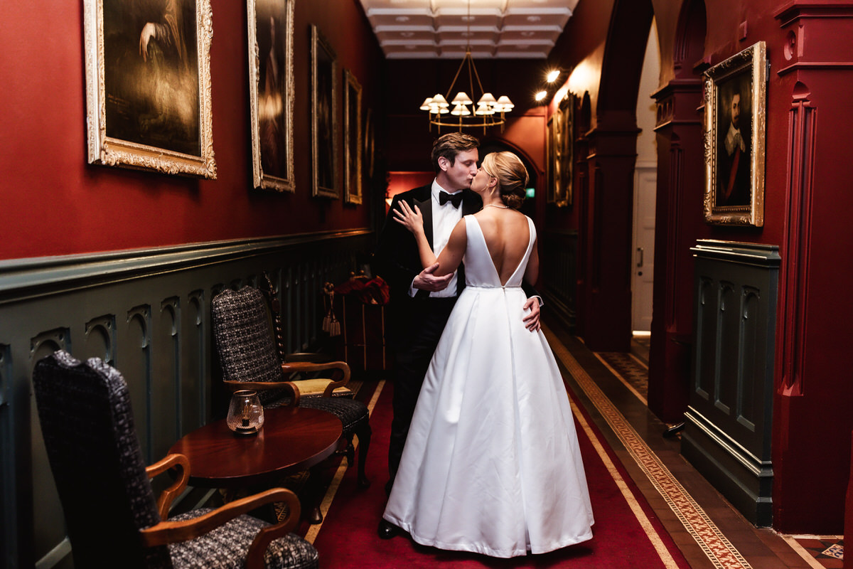 elegant photo of bride and groom kissing in the hotel corridor