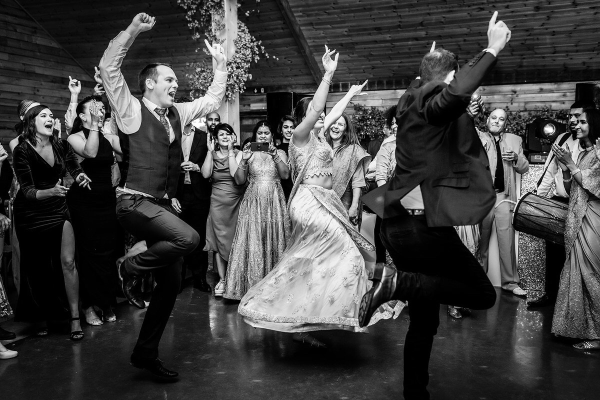 bride and her friends and bridesmaid are dancing an Indian dance at the wedding
