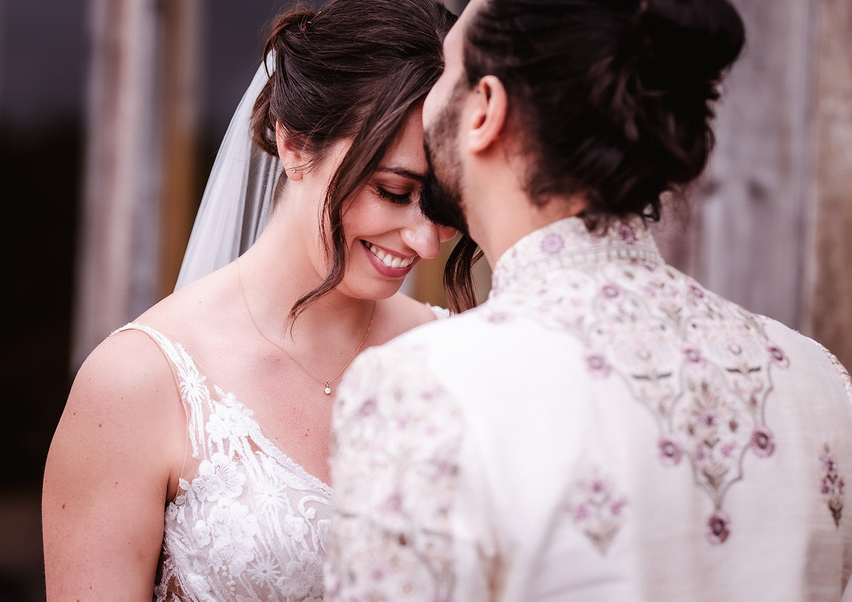 groom is kissing her bride on the forehead