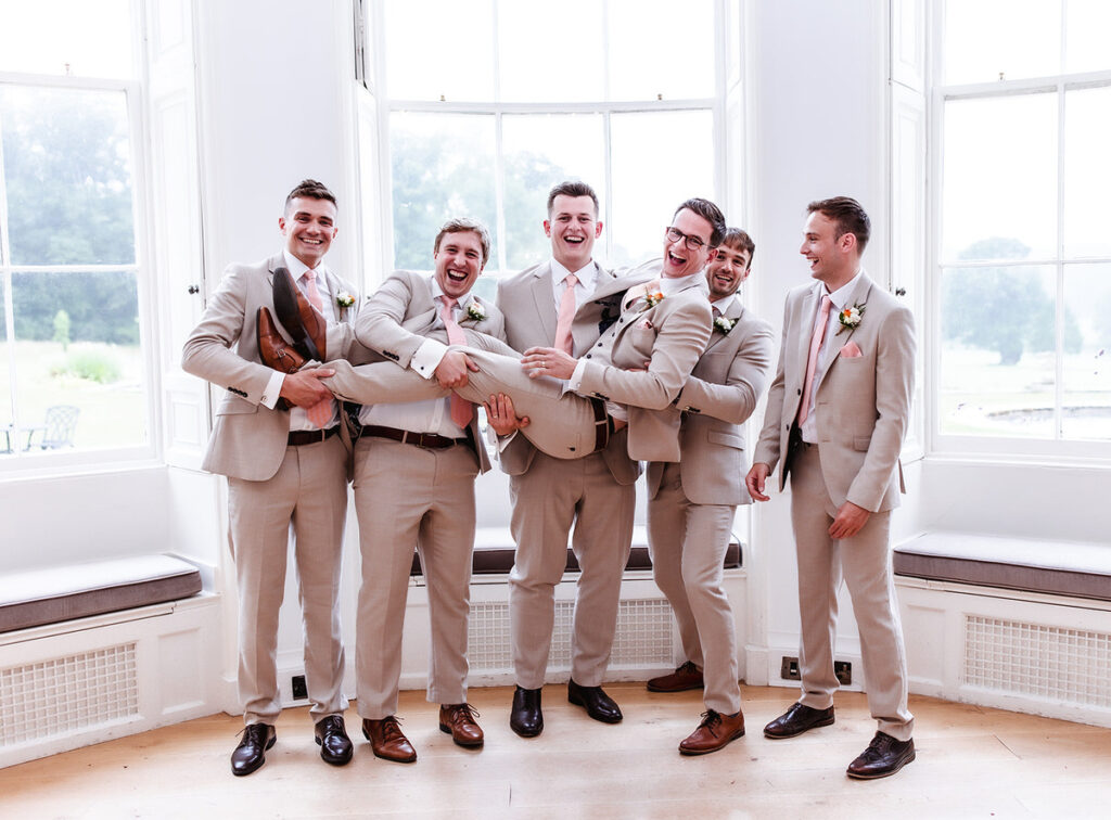 fun photo of groomsmen holding the groom