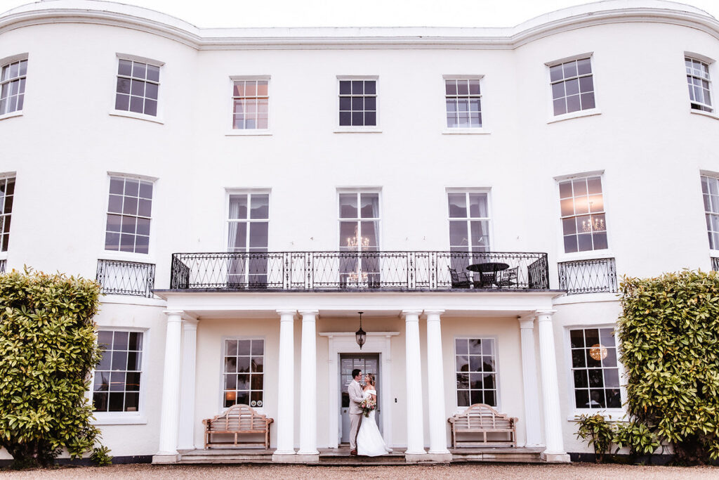 bride and groom standing outside of wedding photos at Rockbear Manor, Devon