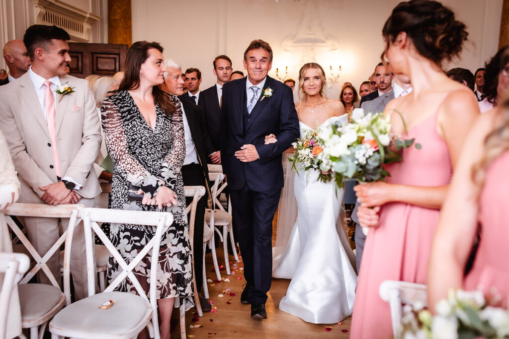 bride is walking down the isle with her dad/father