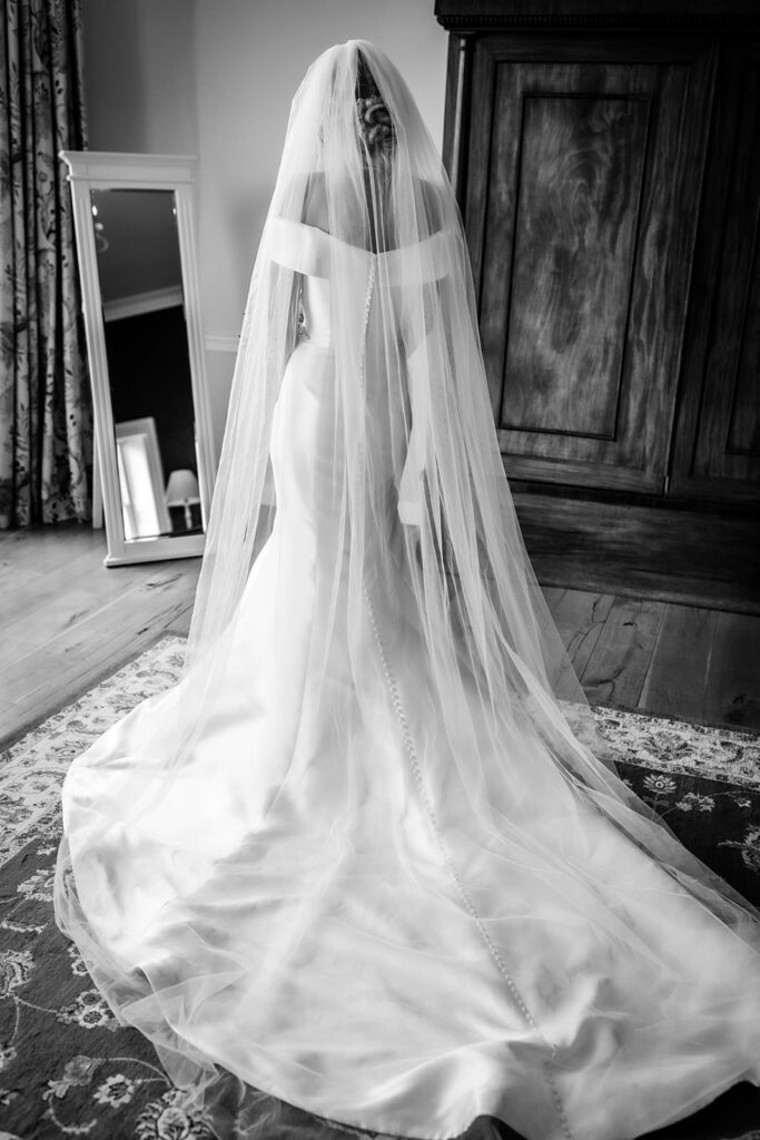 elegant and timeless photo of bride getting ready and looking at her self in the mirrow