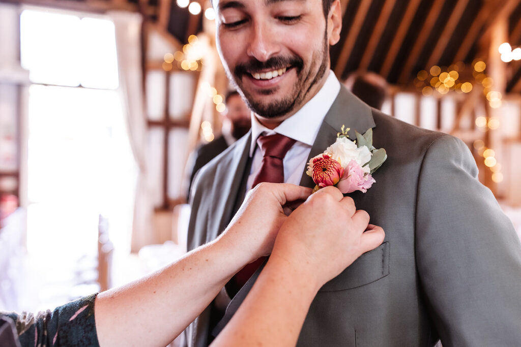 wedding button hole is attached on grooms suit 