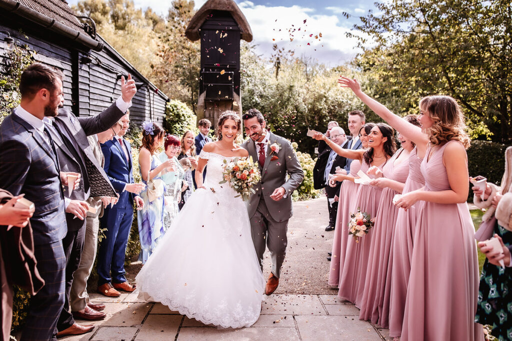 confetti photo of bride and groom outside of clock barn 