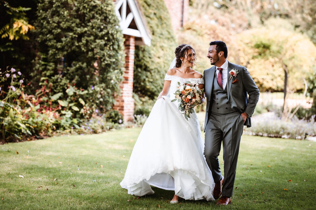 natural photo of bride and groom walking in the garden