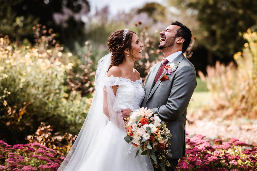 fun and natural photo of bride and groom having laugh in the garden