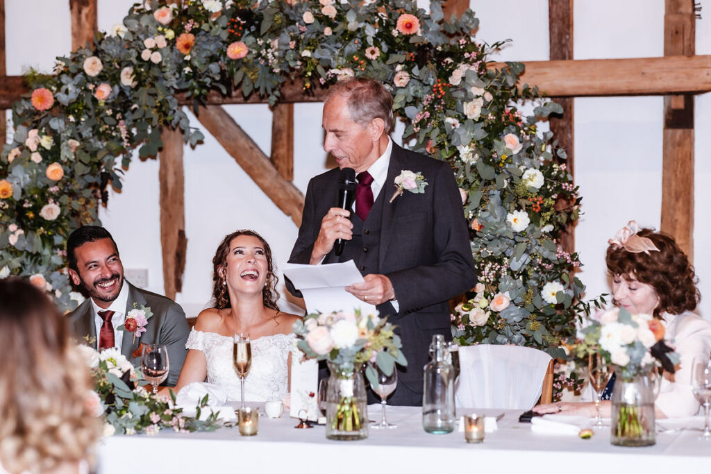 candid photo of bride and groom laughing during the wedding speech