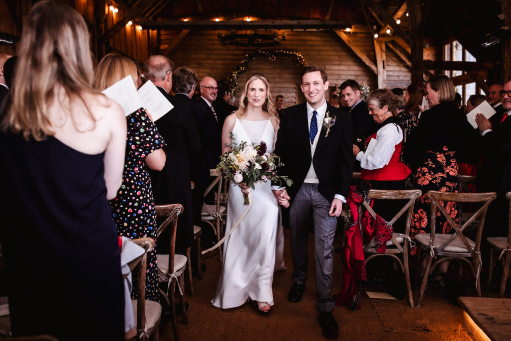 bride and groom leaving the ceremony room. Wiltshire natural wedding photographer