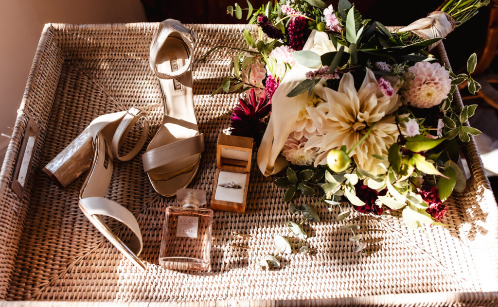 wedding bouget, wedding ring, perfume, wedding shoes on the chair 