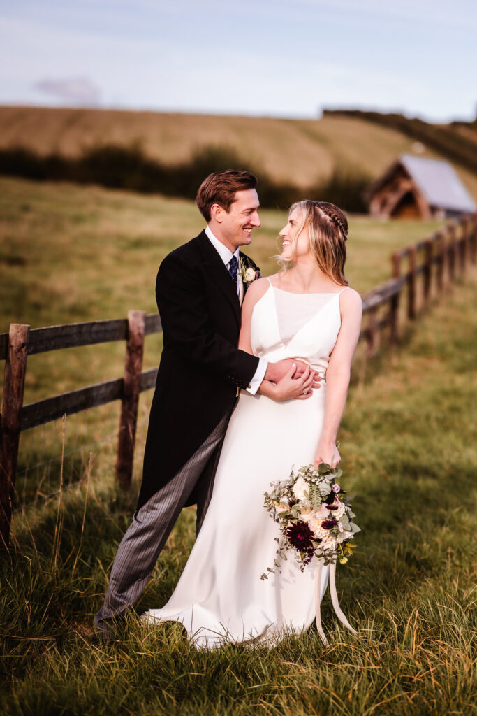 candid photo of bride and groom looking at each other in the field at indoor and outdoor Wilshire wedding venue