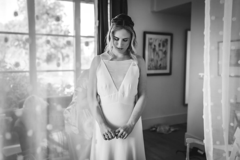 black and white photo of bride getting dressed 