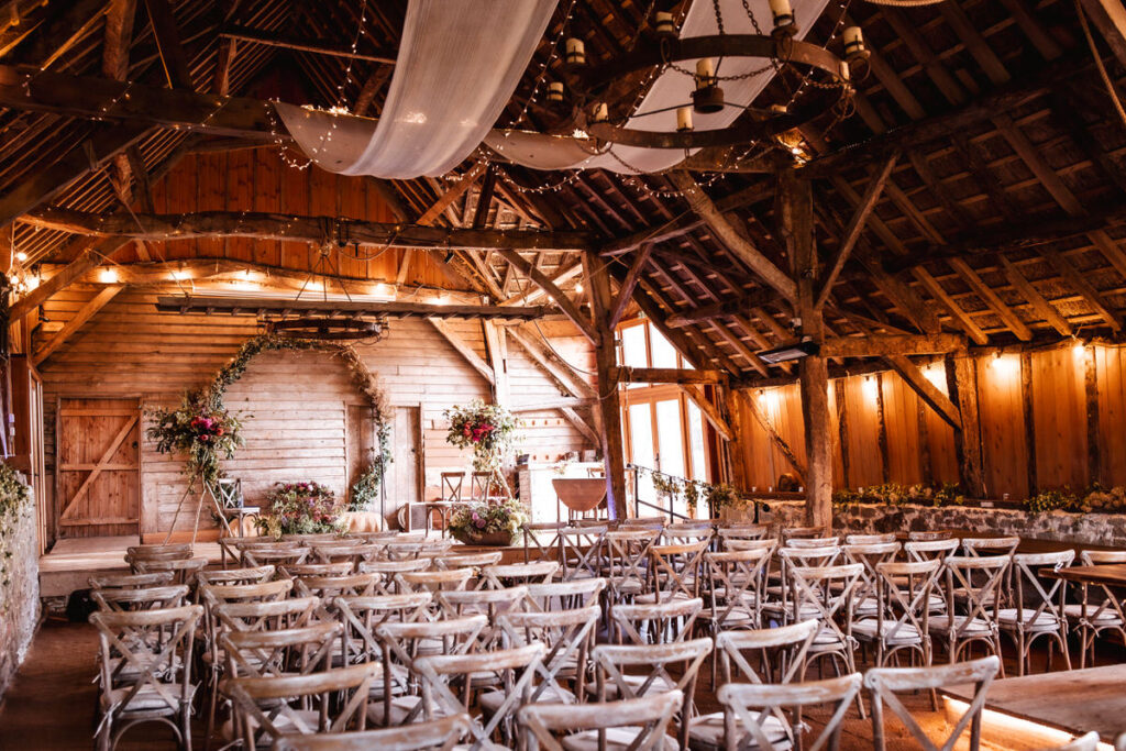 Rustic countryside indoor wedding ceremony at wedding venue at Bowerchalke Barn in Wiltshire