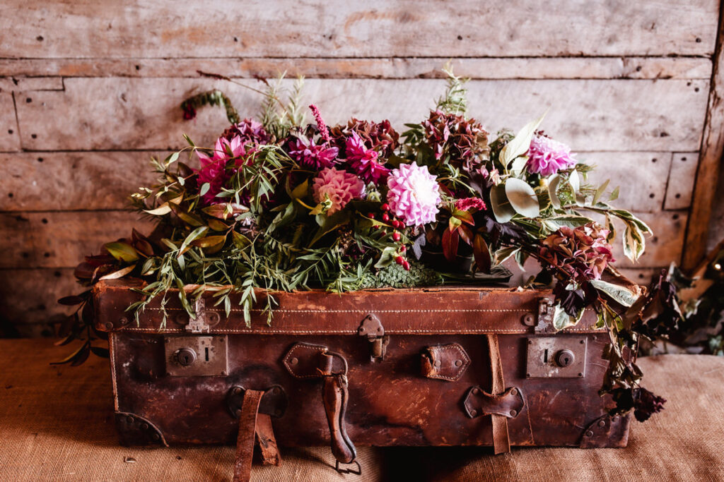 rustic and old fashioned suitcase decorated by wedding flowers