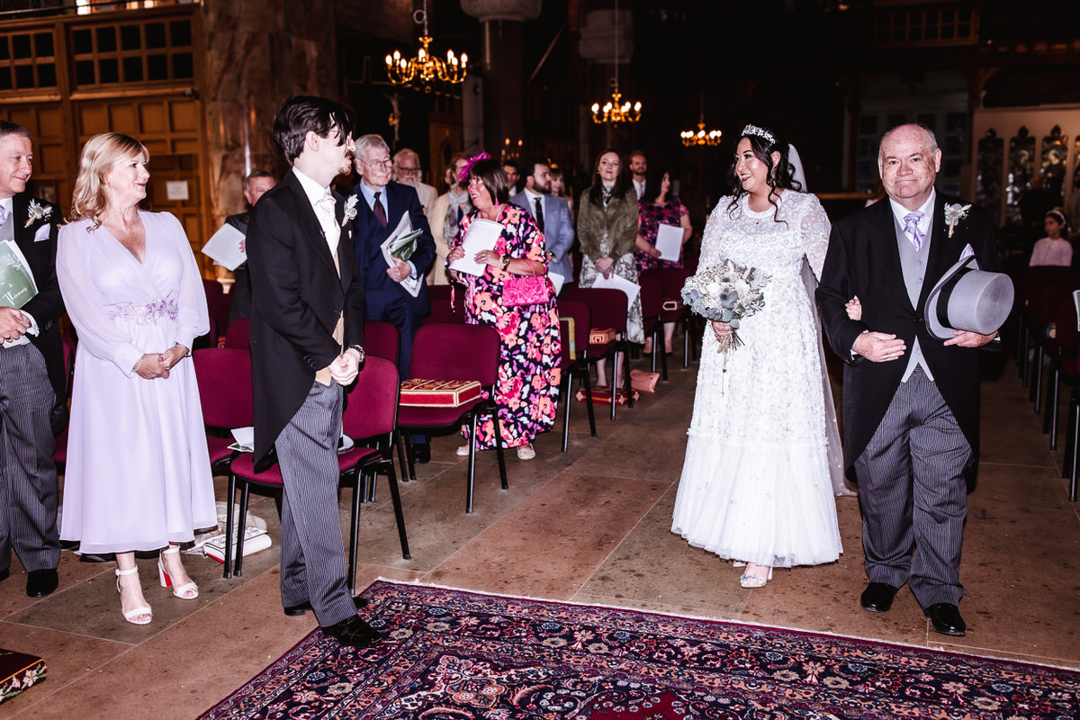 bride is coming down the isle at the church ceremony in Hampshire