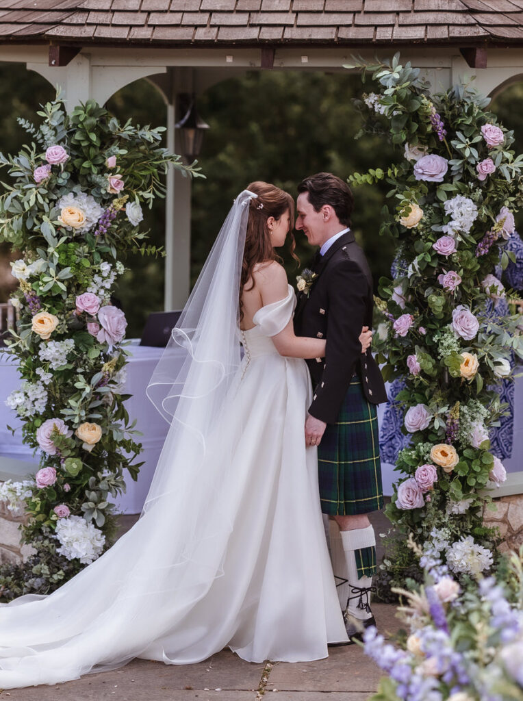 A man and woman in wedding attire kissing.