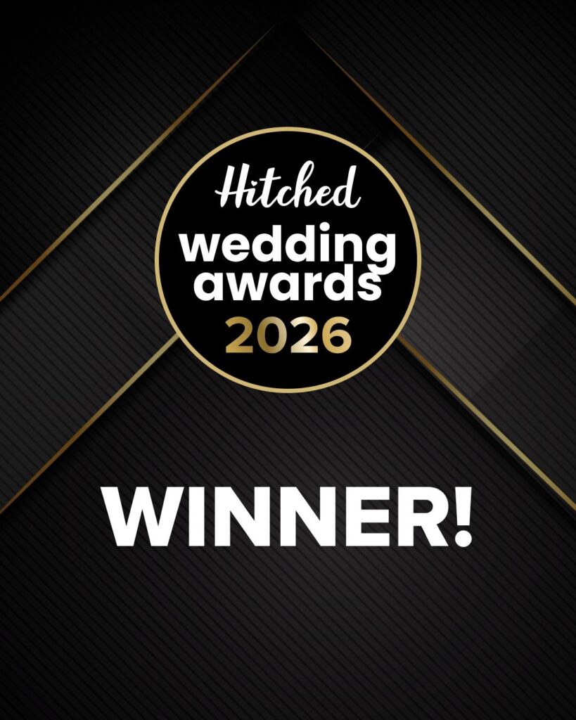 A black and gold graphic with the text Hitched Wedding Awards 2026 in a circular badge above the word Winner! in bold white letters—celebrating an award-winning Hampshire wedding photographer. The background features diagonal lines and gold accents.